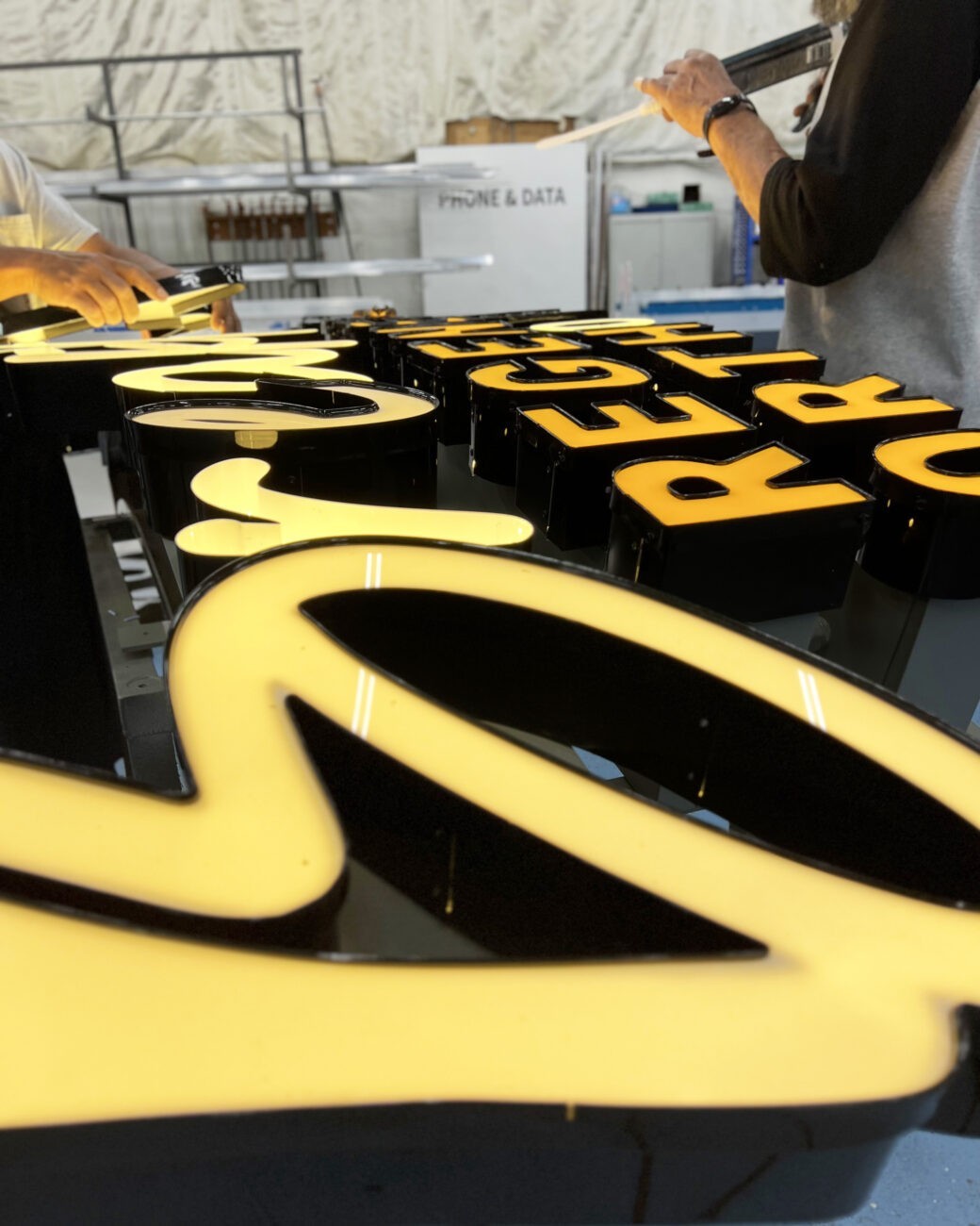 Technician fabricating custom channel letters for a high-visibility storefront sign