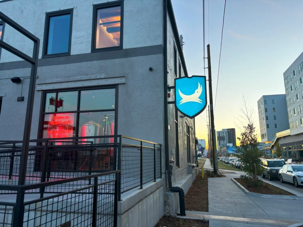 Blade Sign mounted perpendicular to a storefront, projecting outward to increase visibility for street-facing businesses and pedestrian traffic.